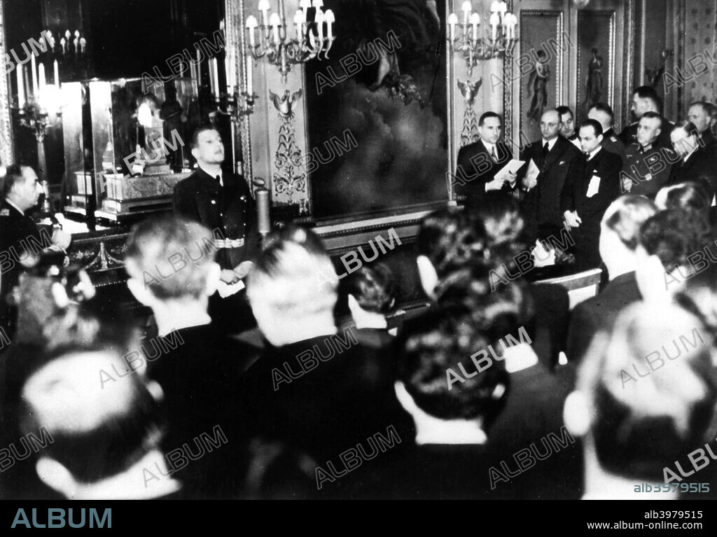 Otto Abetz, German ambassador to France, holding a press conference, Paris, 15 December 1940. He is speaking on the subject of the transfer of the body of the Emperor Napoleon II from Vienna to Paris, a gift from Hitler to the Vichy regime. On the extreme left of the photograph is Fernand de Brinon, a leading French collaborator during the Nazi occupation who was tried as a war criminal by the French after the liberation and executed in 1947.