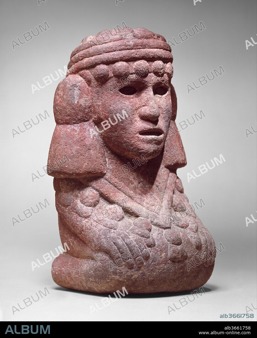 Water Deity (Chalchiuhtlicue). Culture: Aztec. Dimensions: H. 11 5/8 × W. 7 1/8 × D. 5 1/2 in. (29.5 × 18.1 × 14 cm). Date: 15th-early 16th century.
The finely carved figure belongs to a sizable group of kneeling females that display costume elements identifying them as water deities called Chalchiuhtlicue ("she of the jade skirt") in Nahuatl, the language spoken by the Aztecs. In Aztec religion, the water goddess was the wife of the rain god Tlaloc, an ancient deity that had long been worshipped throughout Mesoamerica. Chalchiuhtlicue symbolized the purity and preciousness of spring, river, and lake water that was used to irrigate the fields. As a fertility goddess, she portrays the Aztec ideal of fertile young womanhood. Most typical of the water goddess costume is the distinctive headdress consisting of multiple thick bands, probably cotton, wound about the head and bordered above and below by rows of balls and two large tassels attached to the sides of the head. In back, the bands are twisted and tied in a prominent knot, the tasseled ends falling over her straight hair. Her clothing is that of a noble woman with a skirt and triangular shoulder cape bordered by a tasseled fringe. The water goddess was closely related to the Aztec corn goddess, Chicomecoatl, who is often also shown wearing this headdress, while holding ears of corn in her hands.