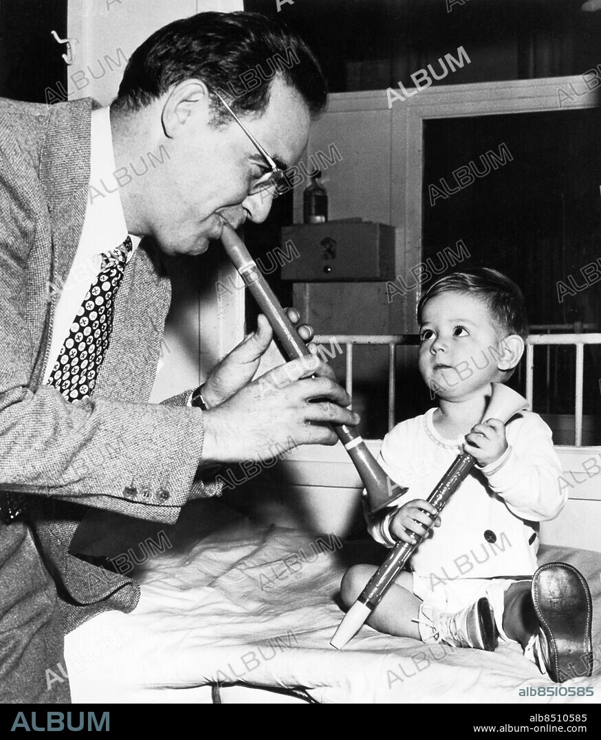 Orig. bildtext... TOOTS FOR YOUNG POLIO VICTIM. New York: The March of Dimes campaign to aid polio victims gets under way on Jan(...) but Benny Goodman didn't wait that long (...) bring some cheer to this young paralyzed (...) boy at Knickerbocker Hospital. Benny and (...) friend both have horns,but Benny's young (...) companion is satisfied to let the famo(...) clarinetist do the playing. Anm. CD100 B. Goodman, 1909-86, amerikansk jazzmusiker, klarinettist och orkesterledare. Polio Gemenskap Klarinetter Blickar Beundrare persons: Benjamin Goodman sites: NEW YORK ;USA.