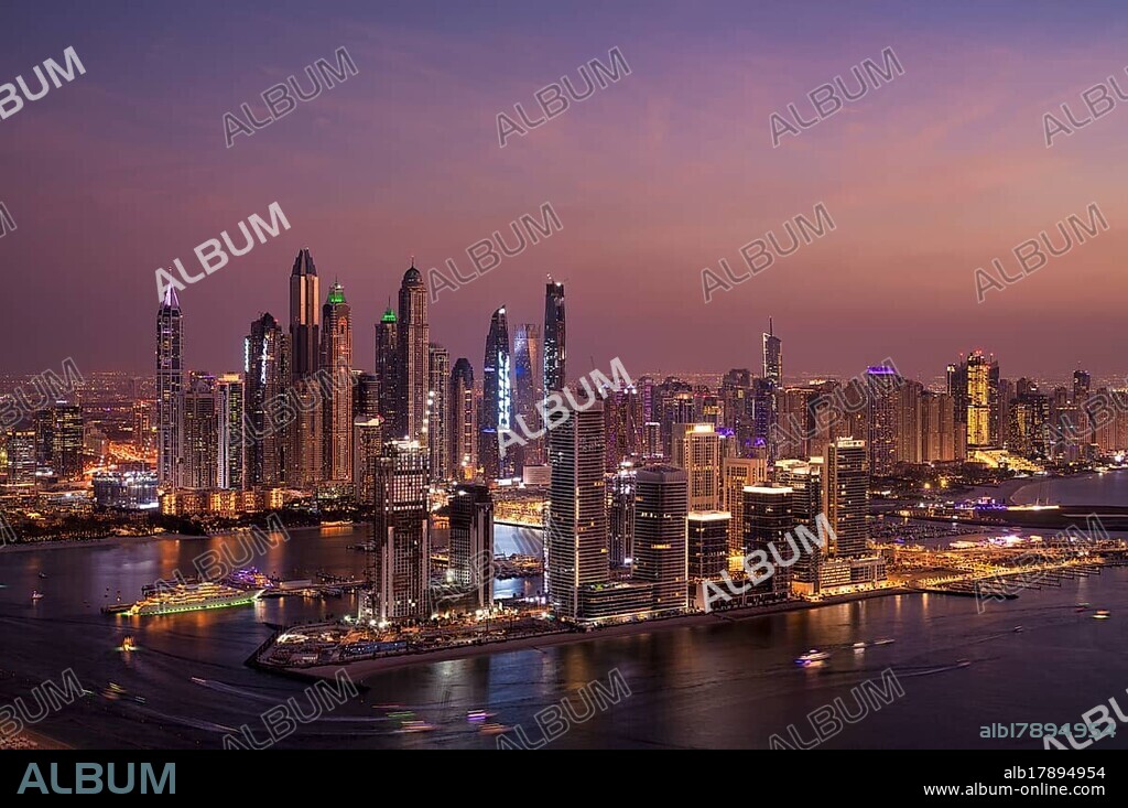 Night shot, view from The View At the Palm viewing platform of skyline with Princess Tower, Elite Residence, luxury yacht OPERA owned by Sheikh Mansour bin Zayed Al Nahyan from the ruling family of the Emirate of Dubai, anchored in front of EMAAR Beachfront, logo, DAMAC, evening mood, Dubai Marina, Dubai, United Arab Emirates, VAR