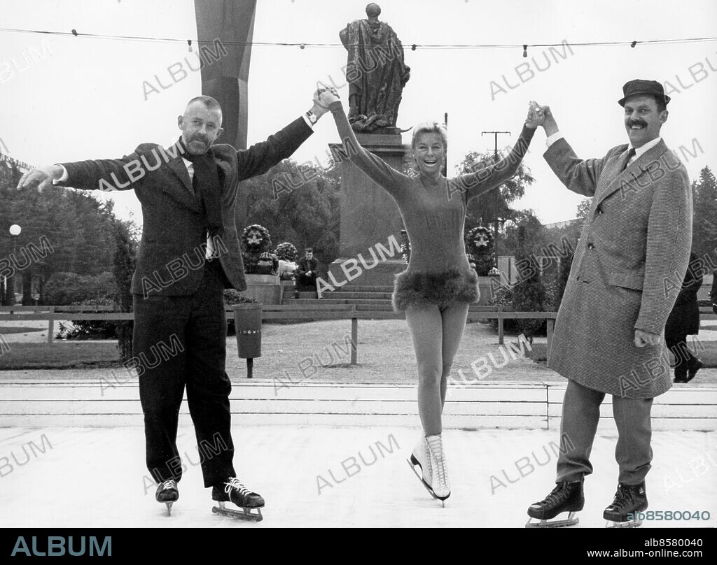 STOCKHOLM 1960-tal.. Orig. bildtext... På fredagen öppnade Kungsträdgården sin isbana för säsongen och samtidigt startade vinterns längsta familjetävling - Familjen Skridsko. Den går ut på att mor, far och minst ett barn så ofta som möjligt i vinter ska ta sig en gemensam tur på banan - och den familj som turast mest får en resa till Kanarieöarna i vår. På bilden dock ingen familj utan snarare de första på isen - Röda Korsets informationschef Allan Schulman, Maj-Britt Röningberg och basen för all parkunderhållning i Stockholm, Lennart Ahlbom. Anm. Allan Schulman, 1919-2003, finlandssvensk journalist och TV-producent; informationschef hos Svenska Röda Korset 1965-1967. Maj-Britt Röningberg, 1923-2001, svensk konståkare. Trio Skridskor Marknadsföring Röda Korset CD652 persons: MAJ-BRITT RÖNNINGBERG;ALLAN SCHULMAN;LENNART AHLBOM sites: STOCKHOLM;KUNGSTRÄDGÅRDEN;SVERIGE.
