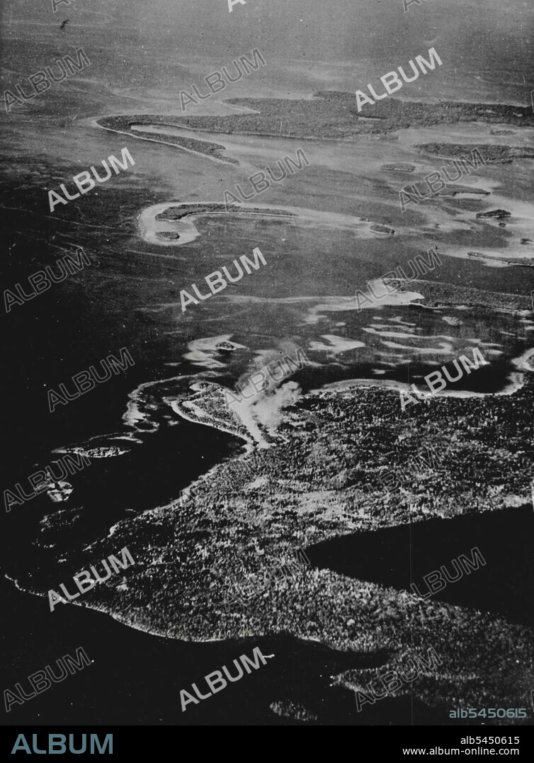 Japanese Base at Mund point Bombed This aerial view of Munda point, near the Japanese base of Munda on new Georgia islans in the central Solmons, shows smoke rising along the runway of a Japanese air field during a bombing attack by American planes. Allied forces launched an offensive in the central Solmons group by landing at Rendova Island, only five miles from Munda. December 06, 1949.