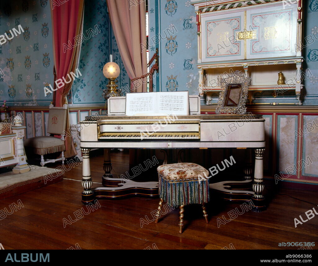19th century Ivory covered piano in a salon of the Château de Roquetaillade; a castle in Mazères (near Bordeaux), France. The extraordinary interior decorations, with its furnishings and paintings, were created by Viollet-le-Duc during the 19th century. Eugène Emmanuel Viollet-le-Duc (1814 - 1879) was a French architect and theorist, famous for his interpretive "restorations" of medieval buildings.