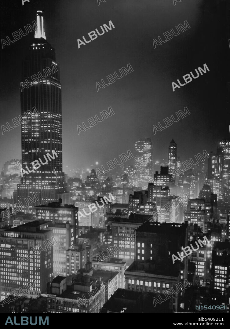 The Empire State Building is a 10-story Art Deco skyscraper in Midtown Manhattan, NYC. The building has a roof height of 1,250 feet and stands a total of 1,454 feet tall, including its antenna. The Empire State Building stood as the world's tallest building for nearly 40 years. A symbol of NYC, the tower has been named as one of the Seven Wonders of the Modern World by the American Society of Civil Engineers. The Empire State Building and its ground-floor interior have been designated as a city landmark by the New York City Landmarks Preservation Commission, and designated a National Historic Landmark in 1986. Vincent Lopez, 1937 (cropped and cleaned).