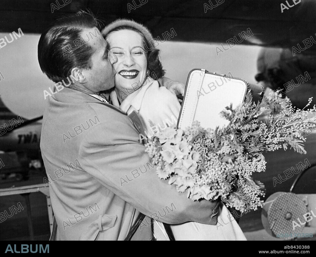 Orig. bildtext... REPLACEMENT FOR MIKE When Kay Young, British actress, arrived at Laguardia Field from Los Angeles today, she was greeted thus fervently by Douglas Montgomery, movie actor, who also said it with flowers. Kay is the former wife of Michael Wilding, who was wed to Elizabeth Taylor recently. She will wed Montgomery in the near future. Anm. Bildarkivets katalog nr7.2 Kramar Skådespelare persons: Kay Young ;Douglas Montgomery sites: NEW YORK ;STORBRITANNIEN* ;USA.