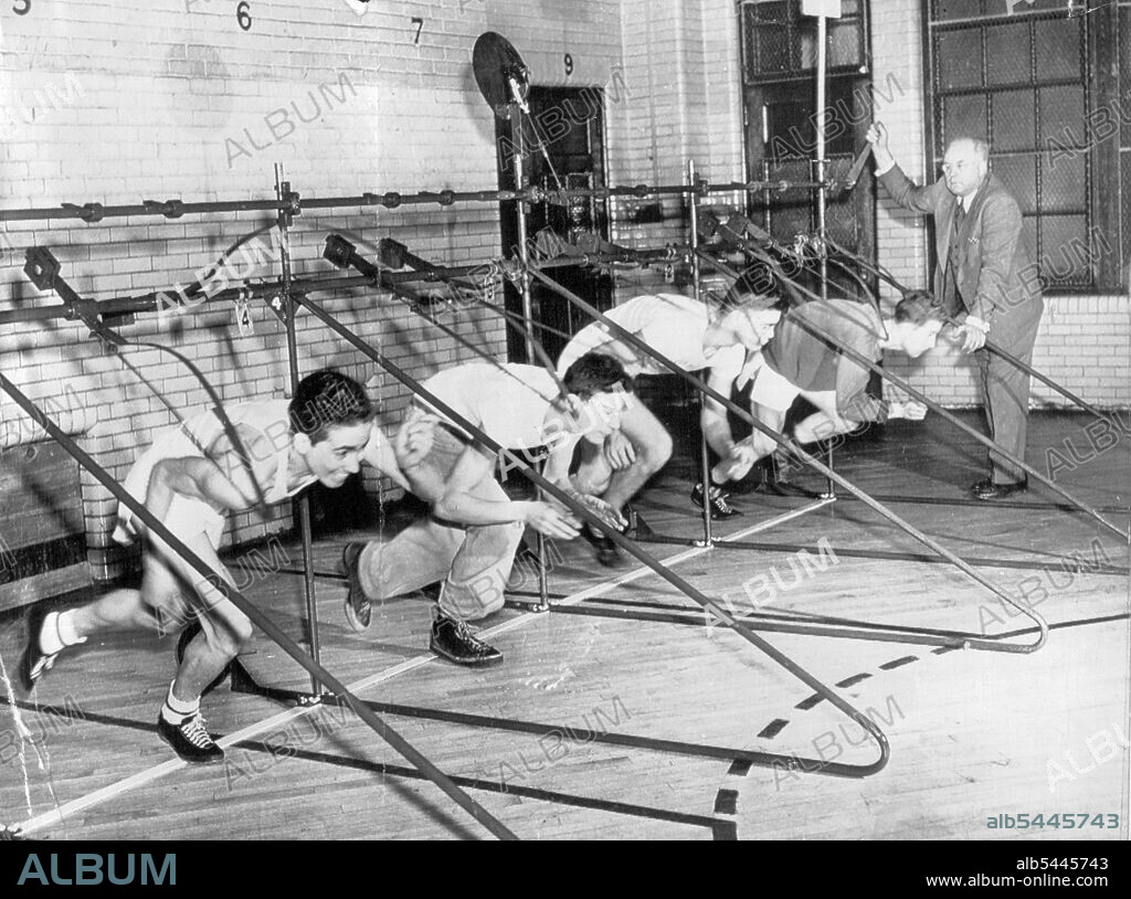 They're Off - Ben Ogden, Temple University track coach, demostrates his automatic starting gate which will be used in the National AAU indoor track and field championships at Madison Square Garden, New York, tomorrow night. The gate's first tryout in a big meet was in the Philadelphia Inquirer's games here last month. They're Off. Ben Ogden, Temple University track coach, demonstrates his automatic starting gate which is being tried in American indoor championships. This trio started evenly. February 18, 1949. (Photo by AP Wirephoto).