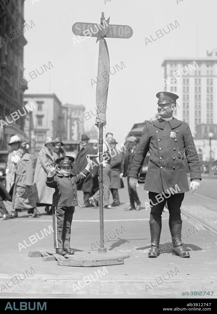 Entitled: "Julius Daranyi, midget traffic cop." Midget is a term for a person of unusually short stature that is considered by some to be pejorative. While not a medical term, it has been applied to persons of unusually short stature, often with the medical condition dwarfism, particularly proportionate dwarfism. Midgets have always been popular entertainers. P. T. Barnum indirectly helped popularize the term "midget" when he began featuring General Tom Thumb, Lavinia Warren and Commodore Nutt in his circus. "Midget" became linked to referencing short people put on public display for curiosity and sport. Barnum's midgets, however, were elevated to a position of high society, given fantasy military titles, introduced to dignitaries and royalty, and showered with gifts. Photographed by National Photo Company June 8, 1924.