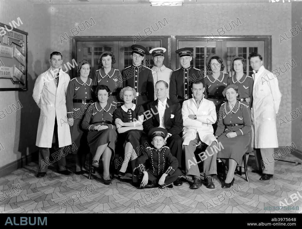 The Odeon, London Road, Isleworth, London, c1935. Group of uniformed staff photographed inside the cinema, including the usherettes and doormen. The carpet has a contemporary Art Deco fan motif, also used in other Odeon cinemas of the period. This cinema was built by George Coles and opened in 1935.