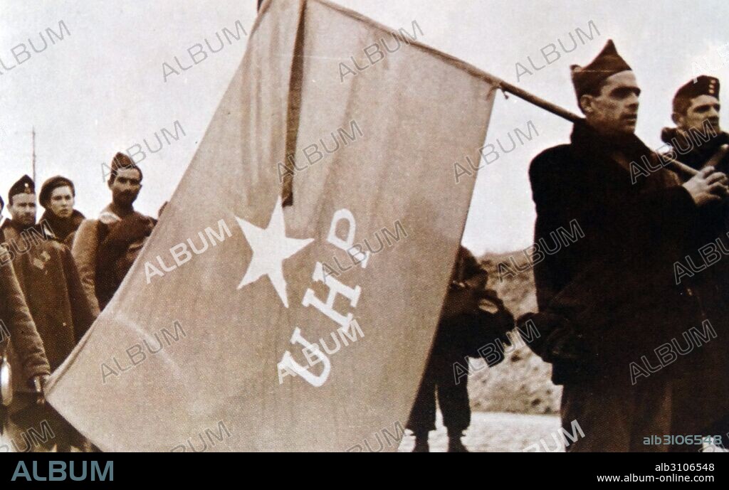 Republican soldiers carry the flag of the UHP (Uníos Hermanos Proletarios or United Brothers of the Proletaria) between battle action in the Spanish Civil War 1936.