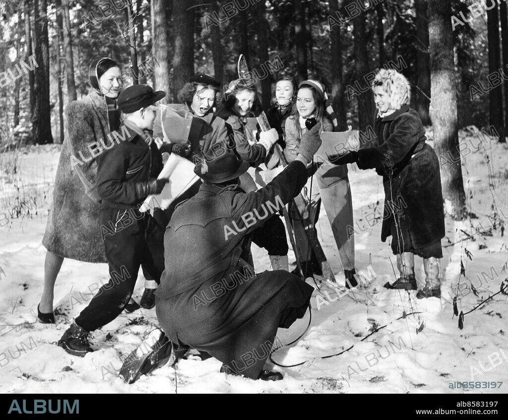 1947.. Inspelning av VINTERLOV. Barnpjäs i radio av Harry Iseborg.. Sänt första gången 1947-02-08.. Här ses från vänster skådespelarna Ingrid Luterkort, Olle Adolphsson, Siv Hansson, Karin Edström, Kari Adolphsson, Stina Flodin och Barbro Svinhufvud. Inspicient Ruben Zehlén håller mikrofon.. Foto: Sören Hoffman / RiR / SVT / Kod: 5600. RiR sv/v. Mapp: Radio-Barnprogram Livet på landet L2. Radioteater.