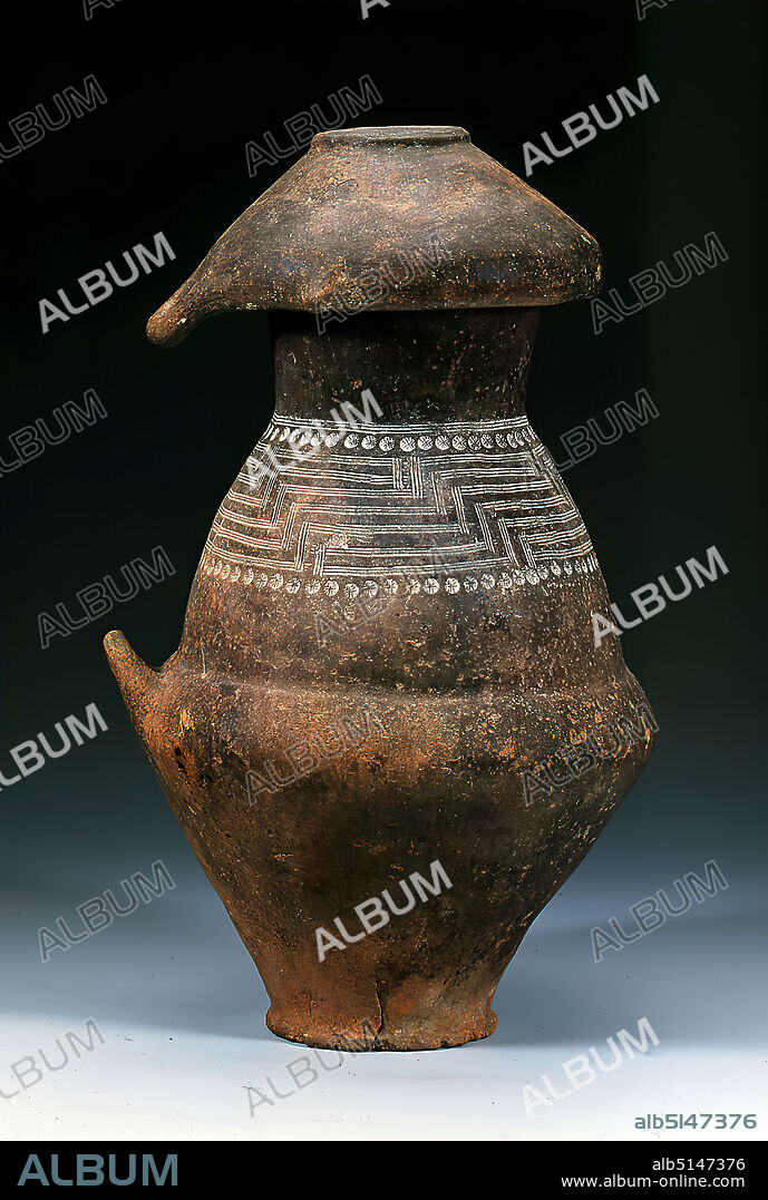 Biconical urn with lid bowl, clay, hand-modeled, fired (pottery), clay, part (vessel): Height: 43.5 cm; Diameter: 22 cm; Mouth diameter: 18.7 cm; Base diameter: 13 cm, pottery, ornaments, meanders, antiquity, The handmade biconical impasto urn with a small handle is closed by a single-linked bowl as lid. The upper part of the urn, which once contained the remains of a cremation burial, is decorated with an incised and stamped decoration: A stepped, meander-like pattern is located between surrounding, stamped stars. Biconical urns are the characteristic vessel forms for burials in the early Iron Age in northern and central Italy. Initially covered with a bowl, bronze helmets were also used, and later moulded heads.