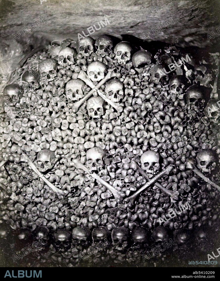 By the end of the 18th century, overcrowded cemeteries in Paris had become a medical problem and city officials began to use the catacombs beneath the streets as a massive burial ground. They were opened to the public and artists soon followed, generating a new interest in the macabre. Although the prefect of Paris officially closed the catacombs to the public in 1830, lovers of the bizarre periodically gained access to the subterranean vaults. Known primarily for his portraiture, Nadar made this photograph of the ghoulish décor with an artificial light of his own design, an early arc lamp known as a Serrin Regulator. Nadar, 1861 (cropped and cleaned).