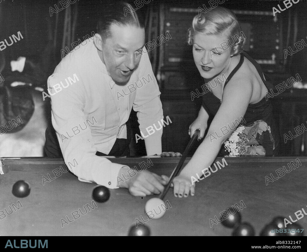 Film Charity Ball - At Pinewood Country Club, Over heath, Bucks., in aid of the Iver Cottage Hospital - Tomo Newman, the famous billiard players, gives Laura La Plante, the wellknown film star, a few hints on Snooker in the billiard room. March 11, 1937. (Photo by Sport & General Press Agency Ltd.).