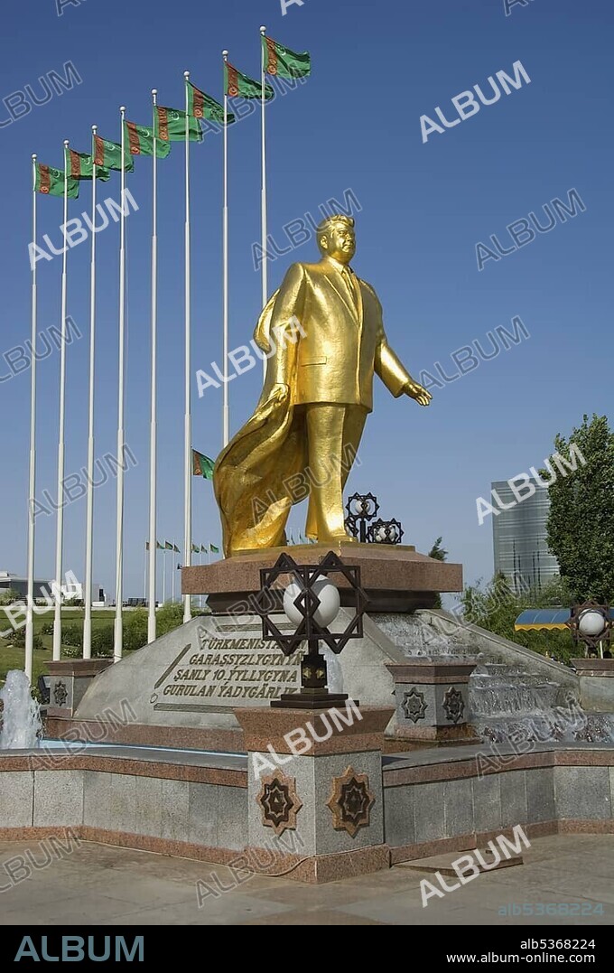 Gold covered statue of President Turkmenbasy in front of the monument of the 10th anniversary of Independence, Ashgabat, Turkmenistan, Asia.