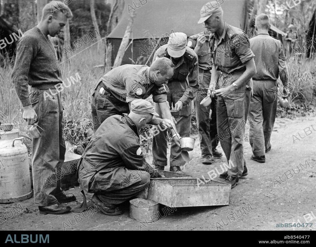 KONGO 1961.. Orig. bildtext... SVENSKA FN-SOLDATER PÅ DJUNGELMARSCH. Delar ur den svenska FN-bataljonen i Kongo är under en veckas tid ute på en 100-mila milamarsch genom Katangas djungler. Klimatet, tsetseflugorna och bristen på vägar har är några av de besvärligheter soldaterna fått pröva på. Vi presenterar här några bilder från enliknande färd som genomfördes från Elisabethville-Mitwaba-Pweto-Elisabethville. En färd på 1887 km. Chef för expeditionen var löjtnant Torvald Fält och truppen tillhörde 3 komaniets 3 pluton. Bilderna visar: 5. Matrasten vid landsvägskanten hör till de populära avbrotten i marschen. Anm. Se även BAH580, BBS746-BBS747 och BBS749-BBS756 Bildserier Fotoreportage Kongokrisen CD506 sites: KONGO;AFRIKA;SVERIGE*.