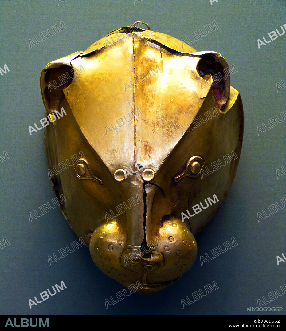Gold rhyton made of hammered sheet metal in the shape of an impressive lion's head with distinctive details, such as the muzzle (which has a pouring hole) and mane.