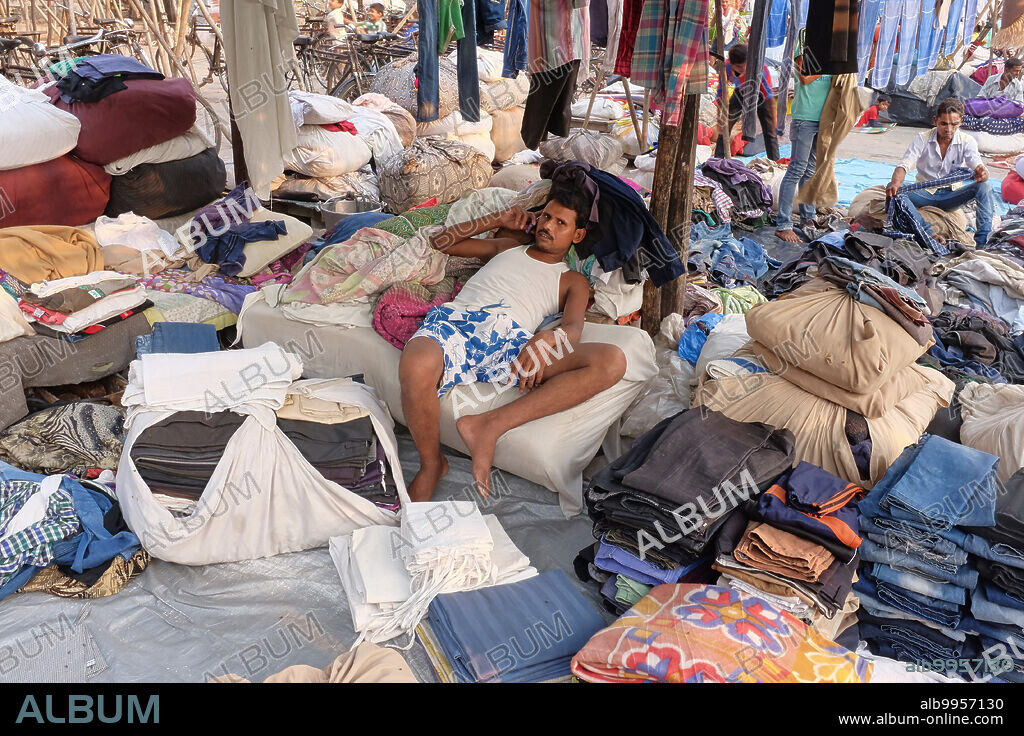 India: A dhobi or washerman of the (lowly) washerman caste Kanaujia, from Uttar Pradesh in North India, at Walkeshwar Dhobi Ghat in Walkeshwar, Mumbai, Maharashtra, relaxing on a heap of laundry. Other castes often working as washermen are the Nirmal and Pardesi castes. All these castes hail from the state of Uttar Pradesh in Northern India.