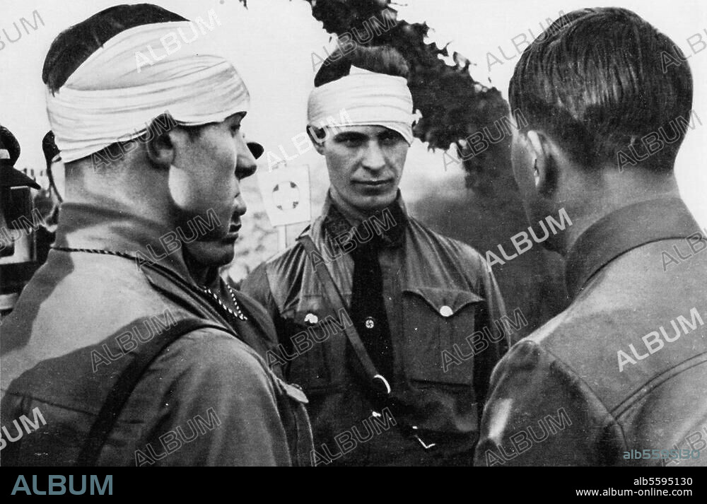 Hitler, Adolf Dictator (NSDAP), 1889-1945. Hitler in conversation with SA men who were injured during clashes with Communists. Photo, c. 1931.