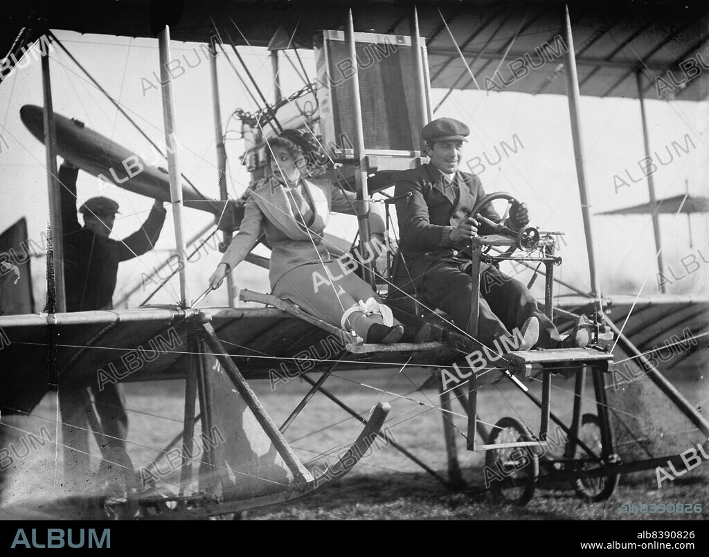 HARRIS & EWING. Senorita Lenore Rivero with Anthony Jannus; In Rex Smith Aeroplane, 1912. Early passenger flight, USA. American aviation pioneer Tony Jannus (1889-1916) in a Rex Smith airplane. This flight was one of several made by Jannus with female passengers over Potomac Park, Washington DC. Ms Rivero was the daughter of the Cuban minister to the USA. Her skirt is securely tied down, and a man stands behind to start the propeller. Jannus made the first ever scheduled airline flight. He died in a crash over the Black Sea during World War I.
