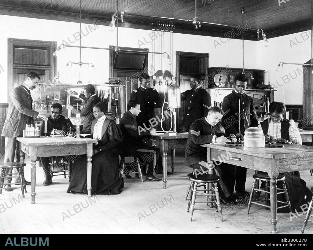 Class in capillary physics at Hampton Institute, 1899. Hampton University is a historically black university located in Hampton, Virginia, United States. The Hampton Agricultural and Industrial School, later called the Hampton Institute, was founded in 1868 after the American Civil War by the black and white leadership of the American Missionary Association, who were chiefly Congregational and Presbyterian ministers. Their goal was to provide education to freedmen. By 1878 it was also teaching Native Americans. A Hampton-style education became well known as an education that combined cultural uplift with moral and manual training. Photographed by Frances "Fannie" Benjamin Johnston (January 15, 1864 - May 16, 1952) was one of the earliest American female photographers and photojournalists. In 1899 she was commissioned to photograph the buildings and students of the Hampton Normal and Agricultural Institute in order to show its success. This series, documenting the ordinary life of the school, remains as some of her most telling work. It was displayed at the ExposÃ© nÃ¨gre of the Paris Exposition Universelle in 1900.