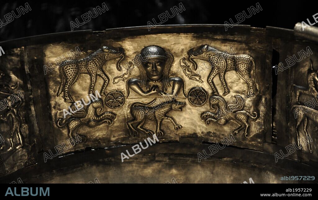 The Gundestrup cauldron. Decorated silver vessel, thought to date between 200 BC and 300 AD, placing it within the late La Te_ne period or early Roman Iron Age. Gundestrup in the Aars parish of Himmerland, Denmark.  Goddess flanked by two six-spoked wheels and two elephantine creatures who seem to posses the body and tusks of a wild boar, the hind legs of a bull and the tusk of an elephant. Two griphins and a large hound are also depicted. National Museum of Denmark.