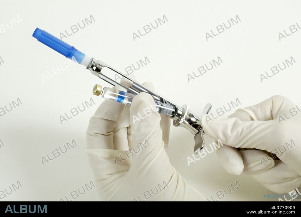 A novocaine carpule is inserted into a anaesthetic syringe by a dentist. A carpule is a type of ampule or cartridge containing liquid medication.