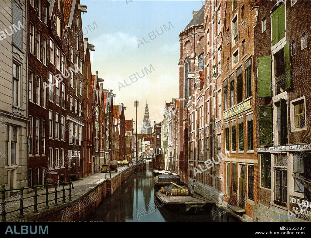 Oude Zijds, the Kolk , Amsterdam, Holland, 1890-1900. View of canal in the old Jewish quarter, with flat-bottomed punts or barges on the water and hand carts on the pavement. Netherlands Transport Architecture.