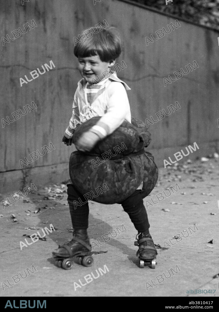 Entitled: "Child roller skating with pillows." The four-wheeled turning roller skate, or quad skate, with four wheels set in two side-by-side pairs( front and rear ), was first designed by James Leonard Plimpton. The skate contained a pivoting action using a rubber cushion that allowed the skater to skate a curve just by pressing his weight to one side or the other, most commonly by leaning to one side. The design of the quad skate allowed easier turns and maneuverability, and the quad skate came to dominate the industry for more than a century. Roller skating is a recreational activity, a sport, and a form of transportation. Photographed by Harris & Ewing, 1924.