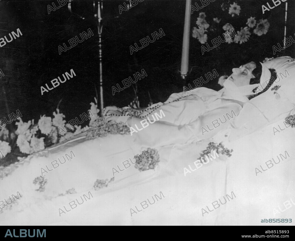 Orig. bildtext... LA MORT TRAGIQUE DE LA REINE ASTRID 31/8/35 Le corps de la Reine Astrid qui avait été embaumé á Lucerne repose dans la chapelle ardente devant laquelle une foule innombrable défile sans arrêt. N.P.M. Le corps de la Reine Astrid. Orig. bildtext... BELGIENS KÖNIGIN AUFGEBAHRT Die sterblichen Ueberreste der Königin von Belgien sind jetzt im Schloss in Brüssel aufgebahrt worden. Die Bevölkerung durfte am Lager der Toten vorbeidefilieren; bis in die Nacht dauerte die Wallfahrt der Tausende, die sich ehrfurchtsvoll vor der Verblichenen verneigten. U.B.z. die Aufbahrung. Orig. bildtext... QUEEN ASTRID LIES IN STATE. 31.8.35. O.P.S. The official picture of Queen Astrid of the Belgians as she lies in state in the Room of Thinkers in the Royal Palace at Brussels. Clad in white satin gown, her head is swathed in silken bandages, which cover the terrible marks made on her face by the force of the accident which caused her death. Thousands passed silently round her bier yesterday paying their last homage. Anm. Astrid, 1905-1935, svensk prinsessa, drottning av Belgien från 1934, gift med Leopold III; avled i en bilolycka i Schweiz. Bandage Svepning Bårar Radband Likvakor CD378 persons: ASTRID, DROTTNING AV BELGIEN sites: SVERIGE*;BRYSSEL;BELGIEN.