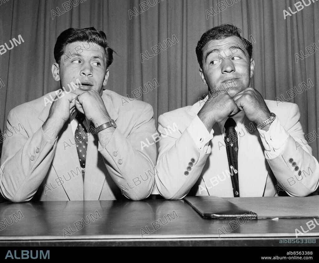 Orig. bildtext... LA STARZA-CHAMP MARCIANO SIGN FOR TITLE FIGHT. New York... Roland La Starza (left) and heavyweight champion Rocky Marciano pose with chins on hands and eye each other furtively after they signed to fight the heavyweight crown on the night of September 24 at the Polo Grounds, New York. Last time Marciano and La Starza clashed there was a wide differens of opinion among the fans as to which won. Marciano got the decision, however. Anm. R Marciano, 1923-1969, världsmästare i boxning, tungvikt, 1952-1956. Gemenskap Ögonkast Ansiktsuttryck Knogar persons: ROCKY MARCIANO;ROLAND LA STARZA sites: NEW YORK;USA.