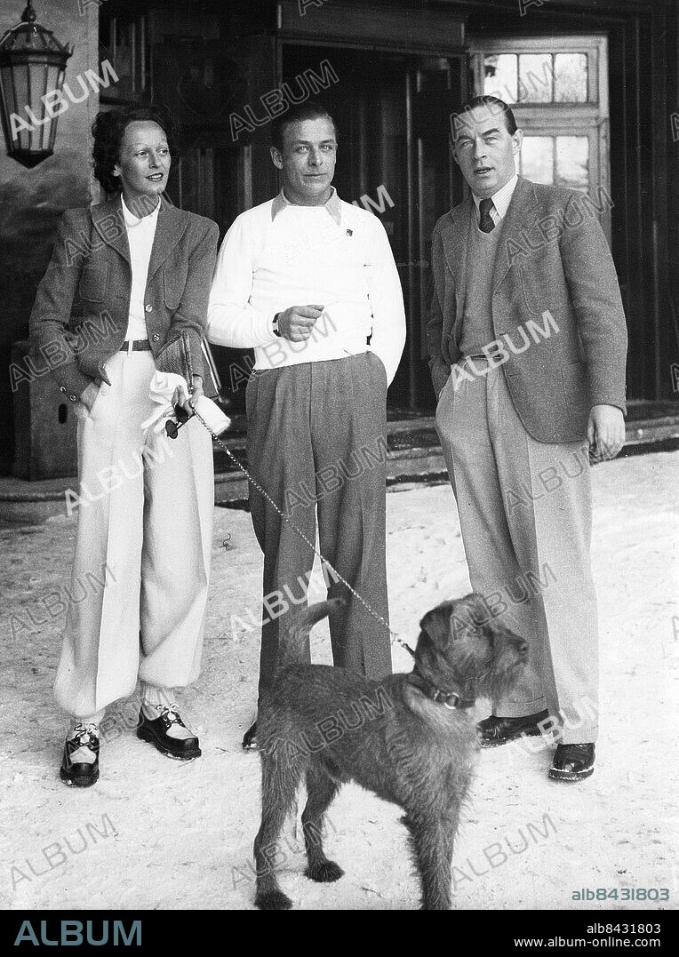 SCHWEIZ SANKT MORITZ 1937-01-13. Orig. bildtext... AUTHOR OF "ALL QUIET" AT ST. MORITZ. Erich Maria Remarque, whose war book "All Quiet on the Western Front" brought him world-wide fame, is on holiday with his wife at St. Moritz, the Swiss winter sports resort. Photo shows Erich Maria Remarque (right) with his wife and Theo MacAvoy (centre) at St. Moritz. Foto: Planet News / AB Text & Bilder / SVT / Kod: 5600 Mapp: Remarque, Erich Maria E M Remarque, 1898-1970, tysk författare, i landsflykt från 1932. I Zambona, gift med E M Remarque 1925-1930, 1938-1957. Ilsa Zamboui Trio Sällskapsdjur Handen i fickan persons: THEO MACAVOY;ERICH MARIA REMARQUE;ILSE ZAMBONA sites: TYSKLAND*;SANKT MORITZ;SCHWEIZ.