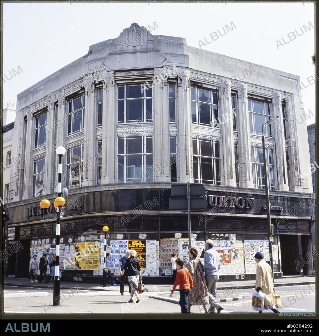 NICHOLAS ANTHONY JOHN PHILPOT. 13-14 Nelson Street, Greenwich, Greenwich, Greater London Authority, 1970s-1980s. The former Burton store on the corner of Nelson Street and Greenwich High Road, showing the curved facade and posters covering the ground floor shopfront. Foundation stones were laid at the Burton store by Stanley Howard Burton and Barbara Jessie Burton in 1932.