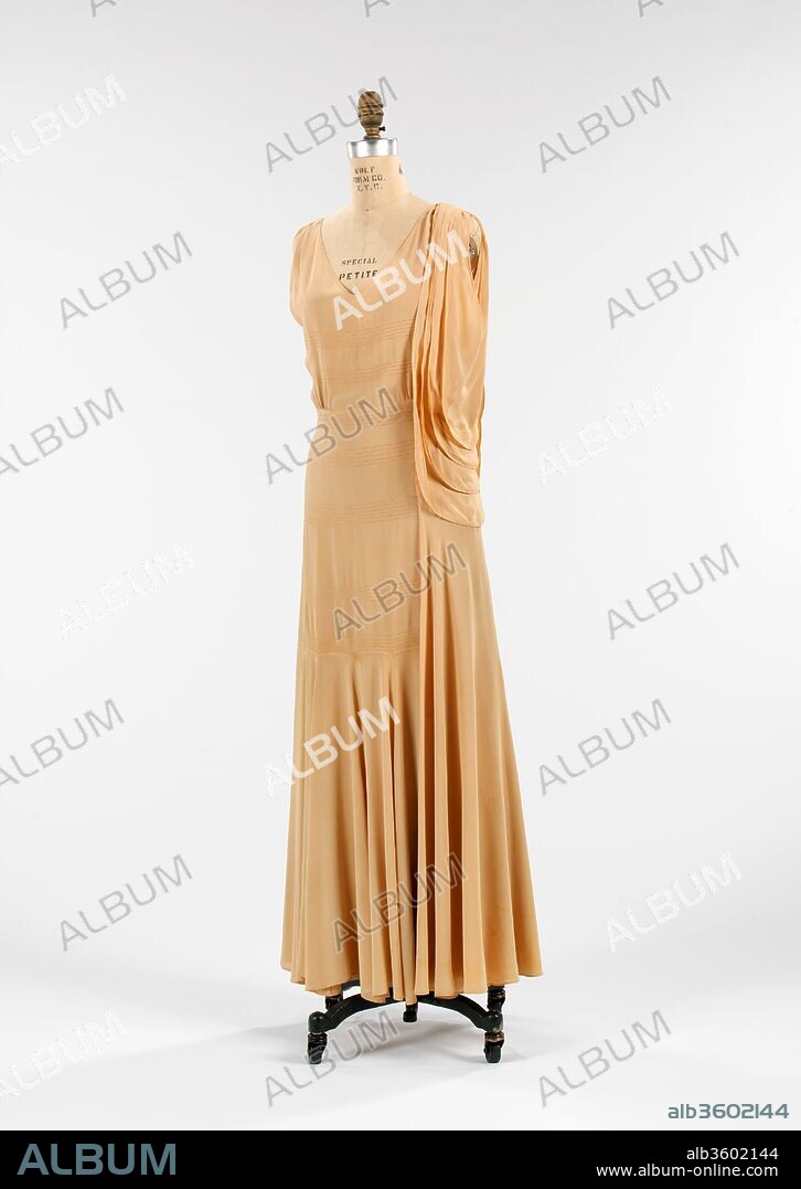 Evening dress. Culture: French. Designer: Paul Poiret (French, Paris 1879-1944 Paris). Date: ca. 1930.
This dress is from the late period of Poiret's career and shows uncharacteristically refined construction and details.
Paul Poiret was the son of a textile distributor with the ambition and creativity to become a fashion designer.  Brief employment for Jacques Doucet (1853-1929) and the House of Worth (1858-1956) led him to open his own dressmaking shop near the Place de l'Opèra in 1903 at the age of 24.  His first two design albums, "Les Robes de Paul Poiret" drawn by Paul Iribe (1883-1935) in 1908 and "Les Choses de Paul Poiret" created by Georges Lepape (1887-1971) in 1911, not only changed the concept of fashion marketing and illustration, they prophesied the pivotal transition women made from the corseted silhouette of the Victorian age into the natural and sleek un-corseted form of the modern era.  The tubular shape and folkloric trimmings he presented were continuously part of the Poiret vocabulary as well as draping, which proved ingenious in the time of tailoring and drafting.