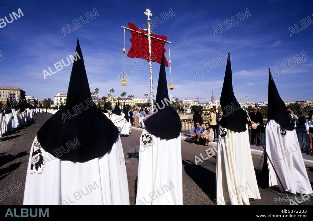 Semana Santa: "Hermandad del Cachorro", nazarenos en puente de Triana.