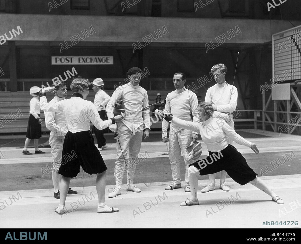 Orig. bildtext... LOS ANGELES Los Angeles, Cal. Members of the Danish Olympic fencing team, pictured in the State Armory, where the teams of all nations are preparing for the Olympic fencing events. In foreground, fencing, left to right, are Grete Olsen and Mrs. Ivan Osiier, wife of the famous Danish fencer. In background, left to right, are Erik Kofoed-Hansen, AAge Leidersdorff, Dr. Ivan Osiier and Axel Bloch. Anm. Sommar-OS En garde Puffbyxor Åskådare CD259 persons: AXEL BLOCH;AAGE LEIDERSDORFF;ERIK KOFOED-HANSEN;GRETE OLSEN;IVAN OSIIER;ELLEN OSIIER sites: LOS ANGELES;USA;DANMARK*.