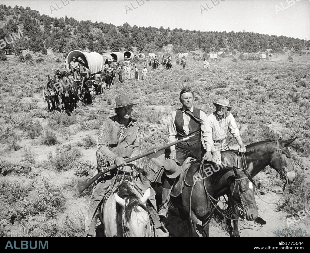 Group scene in the western movie 'The Way West'. A wagon train of settlers in the western movie 'The Way West' is led through the American open grassland by three men on horseback, the US actors Robert Mitchum, Kirk Douglas, Richard Widmark. United States, 1967.