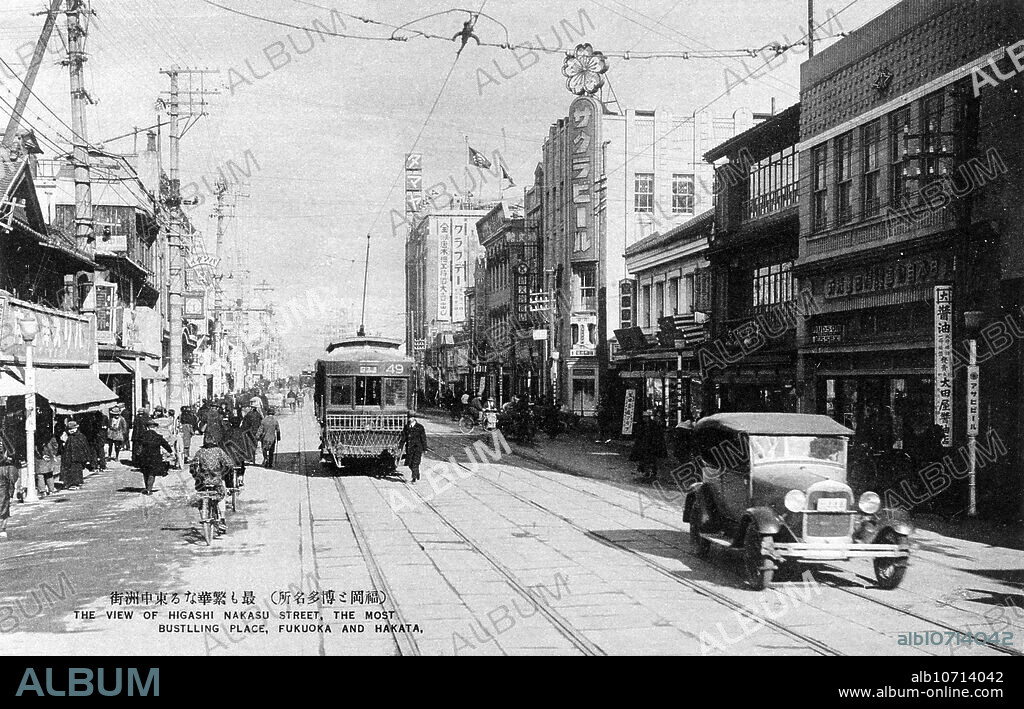 [ 1920s Japan - Car and Streetcar on Japanese Street ] A car and a streetcar in Higashi Nakasu in Fukuoka City, Fukuoka Prefecture. 20th century vintage postcard.