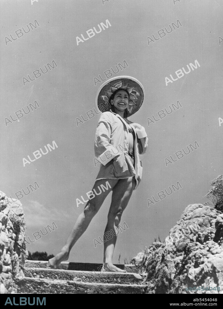 Recongise Margot -- An unfamilar picture of the great English ballerina, Margot Fonteyn, as she relaxes in the sun during her recent vacation. Margot Fonteyn, England's premiere ballerina, is now busy in Edinburgh rehearsing for her forthcoming appearance at the Edinburgh festival to dance in the memory of Serge Diaghilev, famed ballet impressario, but before this she was lazing and relaxing at the beautiful cote d'azur in France. As guest of Paul-Louis Weller, friend gifted amateur of the arts. August 20, 1954. (Photo by Paul Popper, Paul Popper Ltd.).