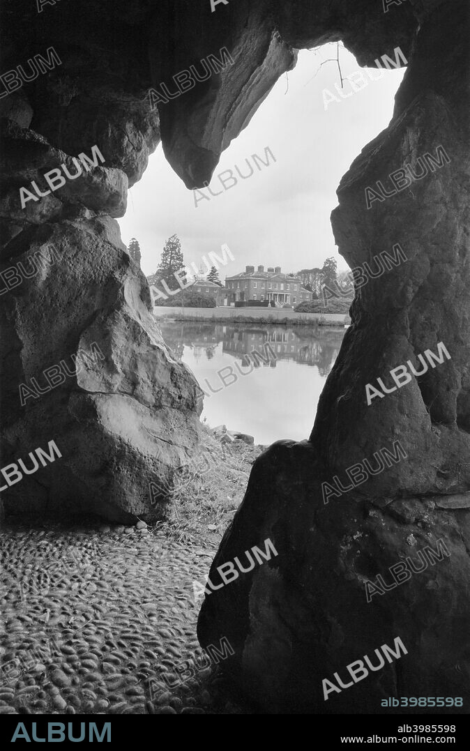 Grotto at Ascot Place, Winkfield, Berkshire, 1945. This romantic grotto was built circa 1750 by Robert Turnbull. The grotto entrance provides a view across the lake towards the house.