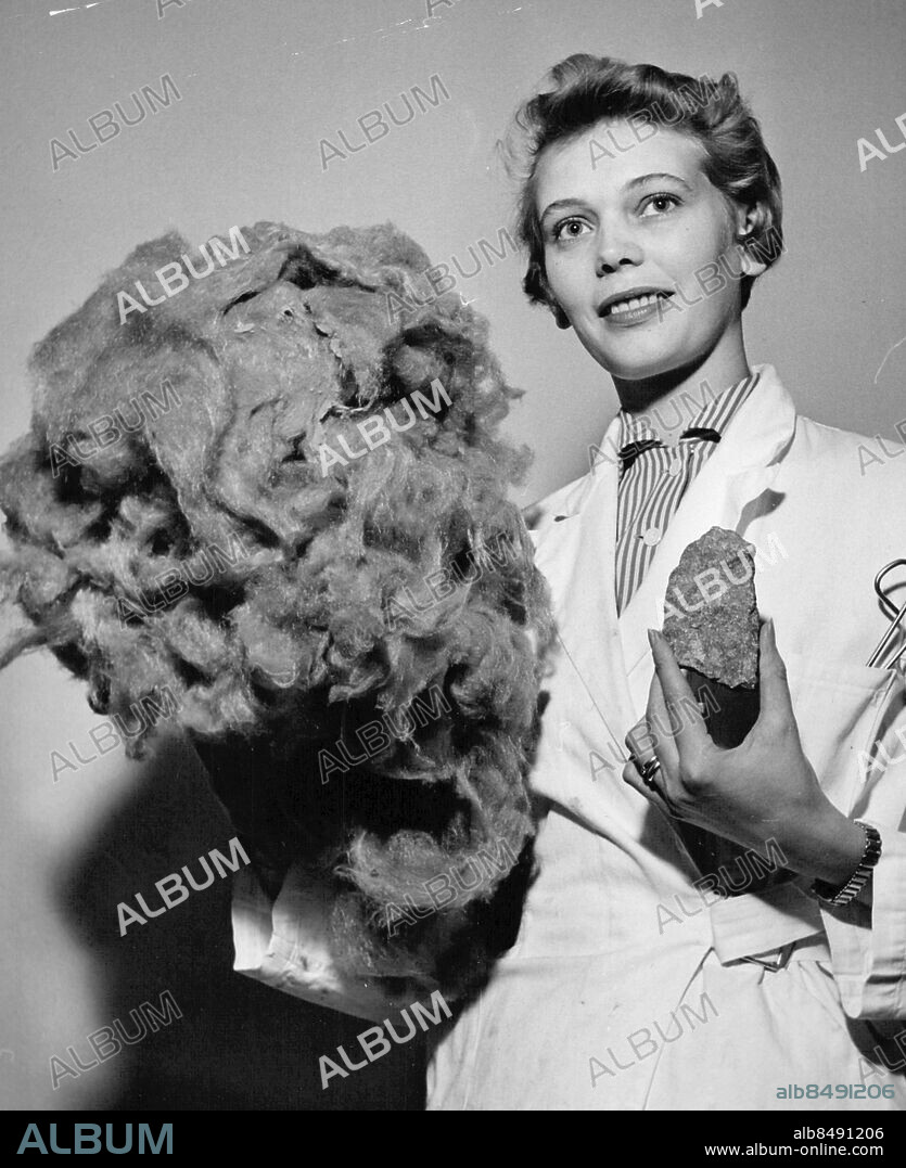 Skövde 1955-12-09. Rockwool AB. Fru Elsa Stenman visar hur mycket stenull det blir av en liten vulkanisk sten från Billingen. Foto: SvD / TT / kod 12014.