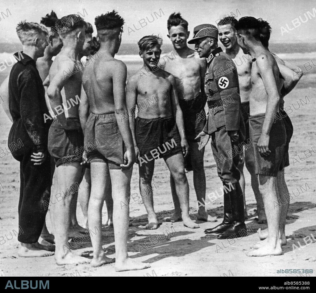 FRANKRIKE Atlantkusten 1943-06. Orig. bildtext... KRIEGSEINSATZ DES REICHSARBEITSDIENSTES AM ATLANTIK. Leibeserziehung am Strande. In der Halbzeit berät der Gruppenführer, selbst alter Handballer, seine Arbeitsmänner. Foto: AB Text & Bilder / SVT / kod:5600 Mapp: Atlantvallen bygges (O.T och R.A.D.) V19:26 Anm. Reichsarbeitsdienst, RAD 1934-1945, en organisation och form av arbetsplikt för att bekämpa arbetslöshet. Arbetsmarknadsåtgärder för arbetslösa Hakkors Samtal AKG France sites: FRANKRIKE;TYSKLAND* PhotoDate:1943-06-??.