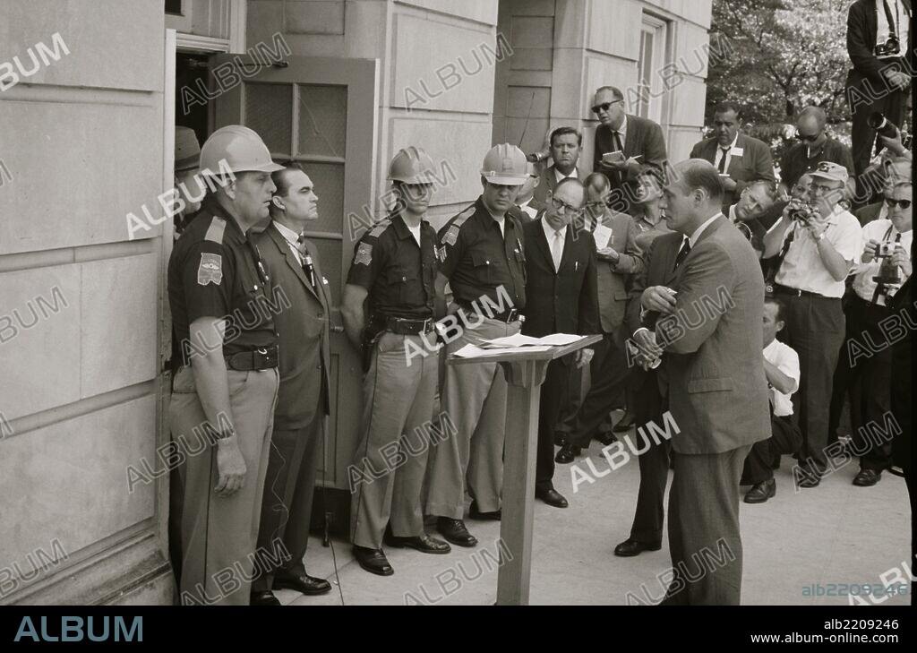 Governor George Wallace attempting to block integration at the University of Alabama; Gov. Wallace standing defiantly at a door while being confronted by Deputy U.S. Attorney General Nicholas Katzenbach.
