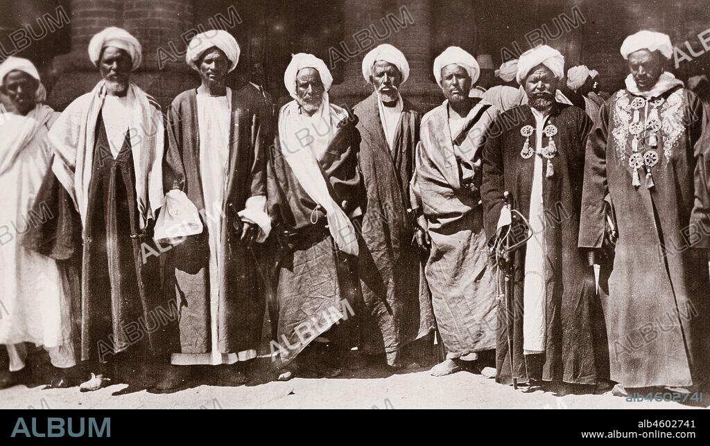Sudan, Printed caption reads: 'Sheikes of Kordofan. Published by G N Morhig, The English Pharmacy, Khartoum. Copyright 115'. Portrait of eight Sheikhs from the Kordofan region of Sudan, wearing traditional Arab dress and turbans, [c.1906]. 2003/222/1/2/47.