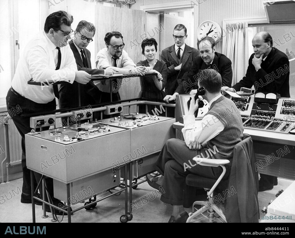 MALMÖ 1962.. Radioredaktionen för Sydkvarten, det regionala nyhets- programmet i P2 för Skåne och blekinge, måndag - fredag kl. 18.35 - 18.50. fr.h. distriktschefen Gunnar Ollén, tekniker Curt Åkeson, redaktör Lennart Kjellgren, redaktör Gary Engman, fru Ruth Törnberg, redaktör Rune Ruhnbro (redaktionschef för Sydkvarten), redaktör Bertil Norlander och redaktör Lars Holmqvist. Bakombild Malmö. persons: GUNNAR OLLÉN ;CURT ÅKESSON ;LENNART KJELLGREN ;GARY ENGMAN ;RUTH TÖRNBERG ;RUNE RUHNBRO ;BERTIL NORLANDER ;LARS HOLMQVIST sites: SVERIGE ;SKÅNE ;MALMÖ.