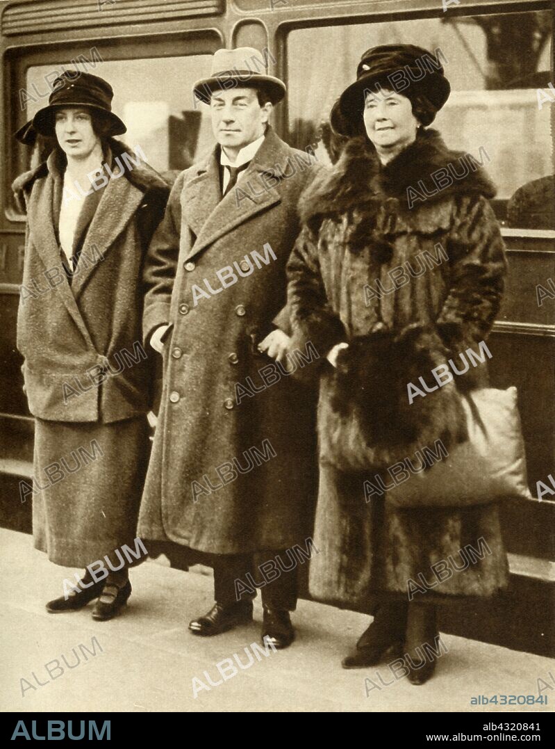 British Prime Minister Stanley Baldwin with his wife and daughter, London, 27 January 1923, (1935). Stanley Baldwin (1867-1947), Conservative Party statesman, with his wife Lucy (née Ridsdale, 1869-1945) and daughter, at Waterloo Station on their arrival in London from America. From "The Silver Jubilee Book - The Story of 25 Eventful Years in Pictures". [Odhams Press Ltd., London, 1935].