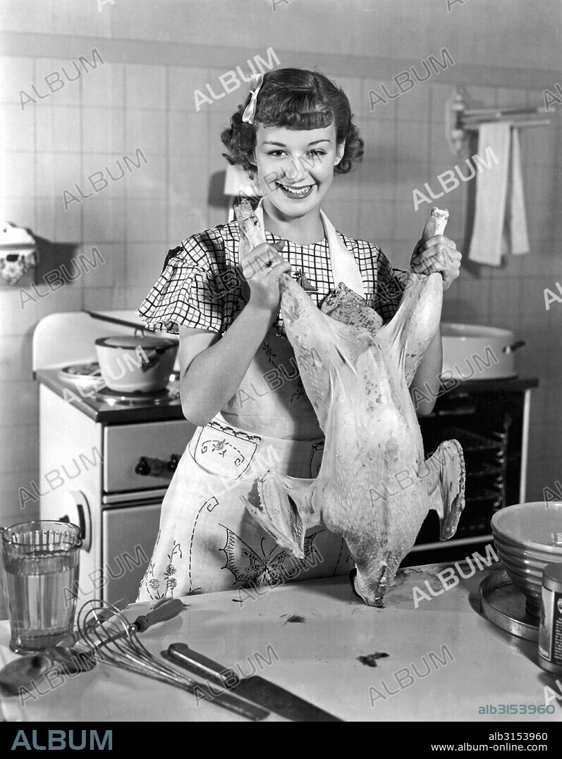 Hollywood, California:  1934. Sixteen year old Anne Shirley, RKO star of Anne of Green Gables, demonstrates how to deal with a Thanksgiving turkey.