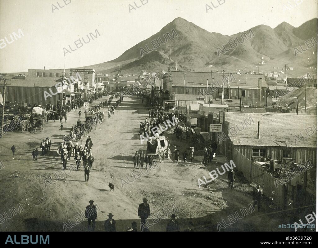 Street Scene, Tonopah, Nevada, 1906. Is The Funeral Precession Of Sheriff Thomas Logan On April 12Th 1906. He Was Killed By Gun Fire Saturday, April 7, 1906. This Is A Great Street Scene From This Early Nevada Mining Town. Sheriff Logan Was Shot And Killed While Coming To The Aid Of A Saloon Matron In Manhattan, Nevada. The Matron Was Being Harassed By A Drunken Gambler Inside. As Sheriff Logan Attempted To Eject The Man From The Saloon The Man Suddenly Pulled Out A Gun And Shot Him Five Times. Although Mortally Wounded, He Was Able To Subdue The Suspect Until A Deputy Arrived At The Scene. Sheriff Logan Was Serving His Third Term As Sheriff And Had Been With The Agency For Eight Years. He Was Survived By His Wife And Eight Children., H.T. Shaw, 1906.