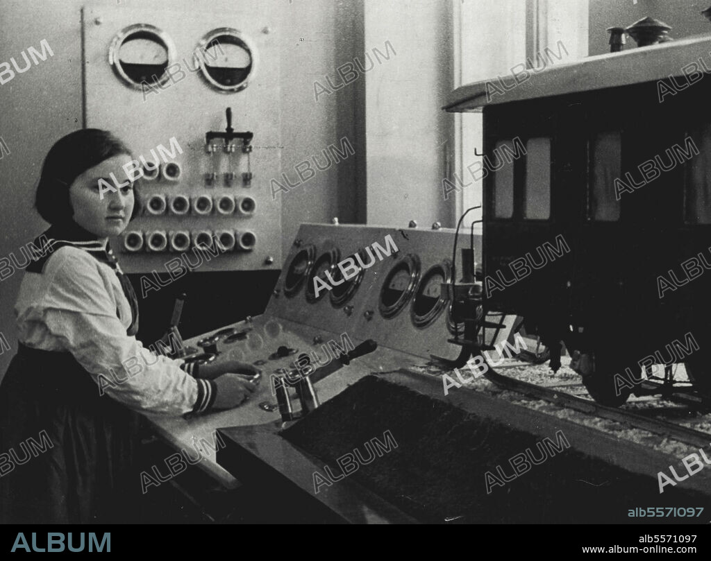 Palace Of Pioneers In The Capital Of Soviet White Russia -- A little dispatcher, a Pioneer girl at the control switch board of the working model of a railway station in the Palace of Pioneers in Minsk, the capital of Soviet white Russia. The white Russian Soviet Socialist Republic is located in the western part of USSR, along the frontier with Poland. In the new Palace of Pioneers every Pioneer school child can find games and lessons to meet his inclinations,The numerous technical rooms and play rooms 3re full of interesting and absorbing models which familiarise the children with technique, art and natural science. July 19, 1937. (Photo by Fishman, Soyuzphoto).