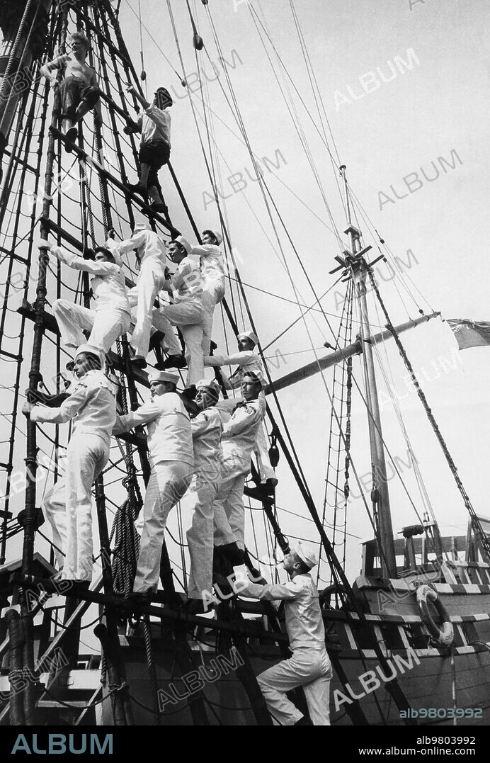New York, Cutty sark's Godfrey Wicksteed tops with guitarist Graham Nunn during sailors rope instruction, 1957.