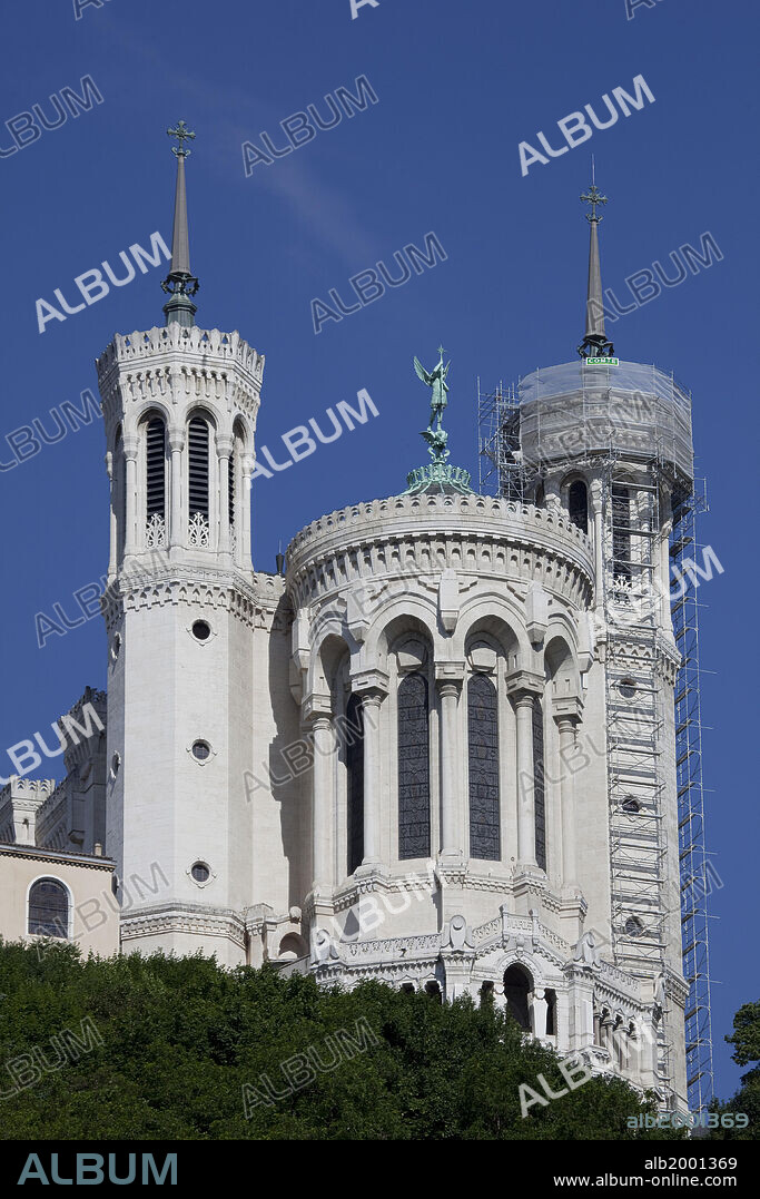 The Basilique Notre-Dame de Fourviere sits high atop the Fourviere Hill in Lyon, France. Designed by Pierre Bossan and built between 1872 and 1876, it is in neo-Byzantine style, with slender turrets on its four corners and crenellated walls. A gilded statue of the Virgin surmounts the bell tower and a statue of St. Michael surmounts the apse. The Saint-Jean and the Croix-Rousse areas in the city of Lyon were designated  UNESCO World Heritage Sites in 1998, for their historical and architectural landmarks.
